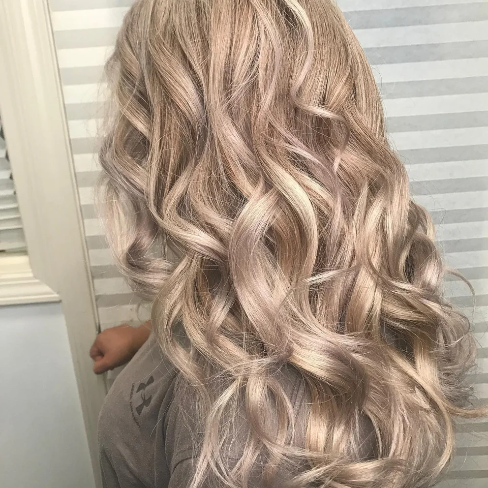 Long champagne blonde hair styled in polished curls