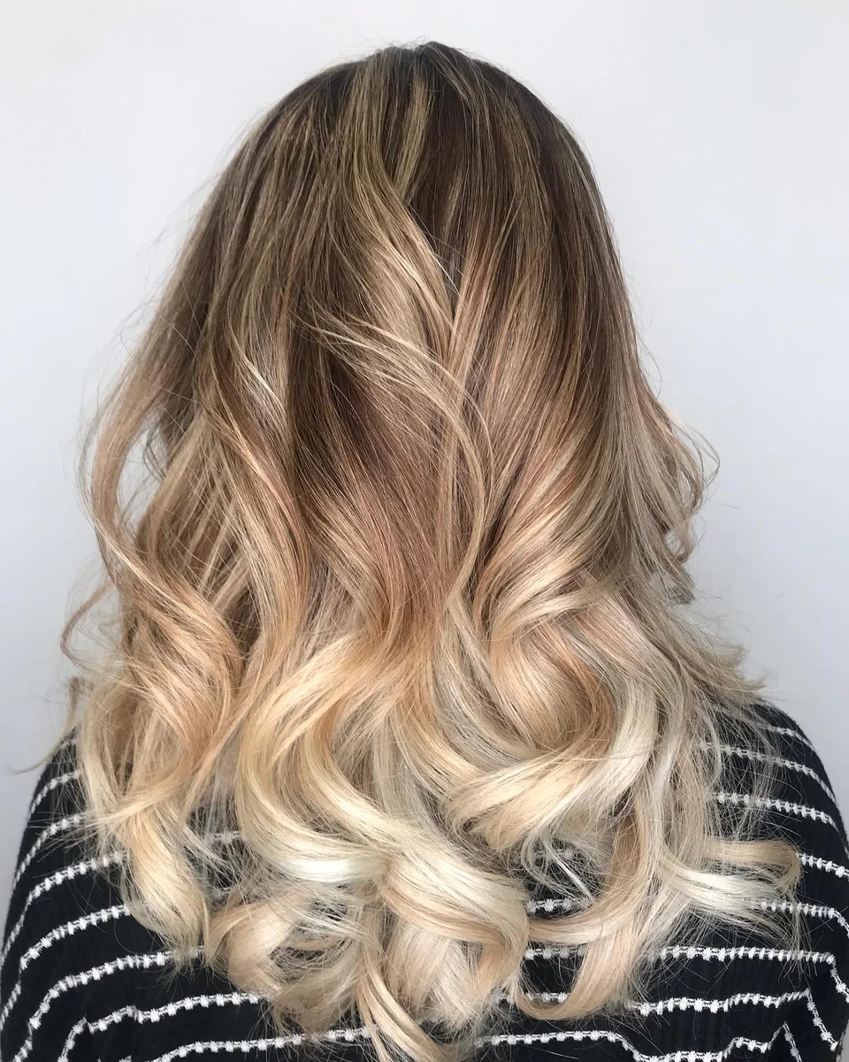 Long dimensional blonde balayage styled in curls