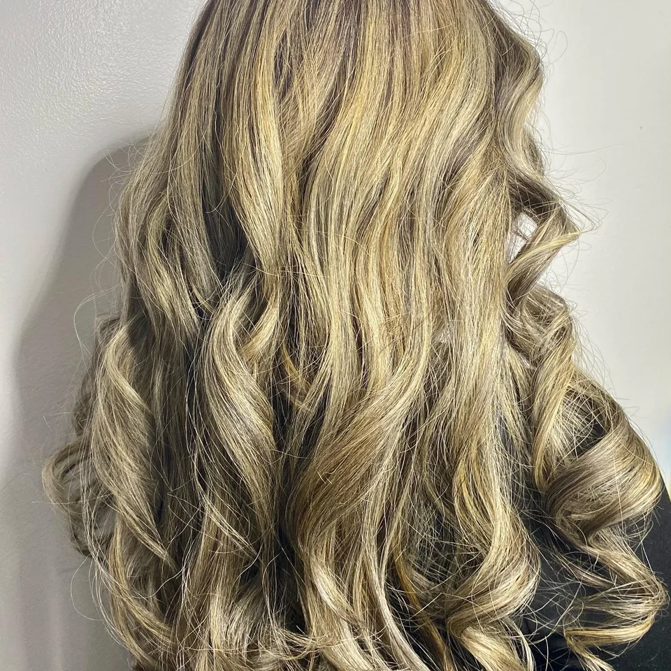 Long blonde highlights styled in soft curls
