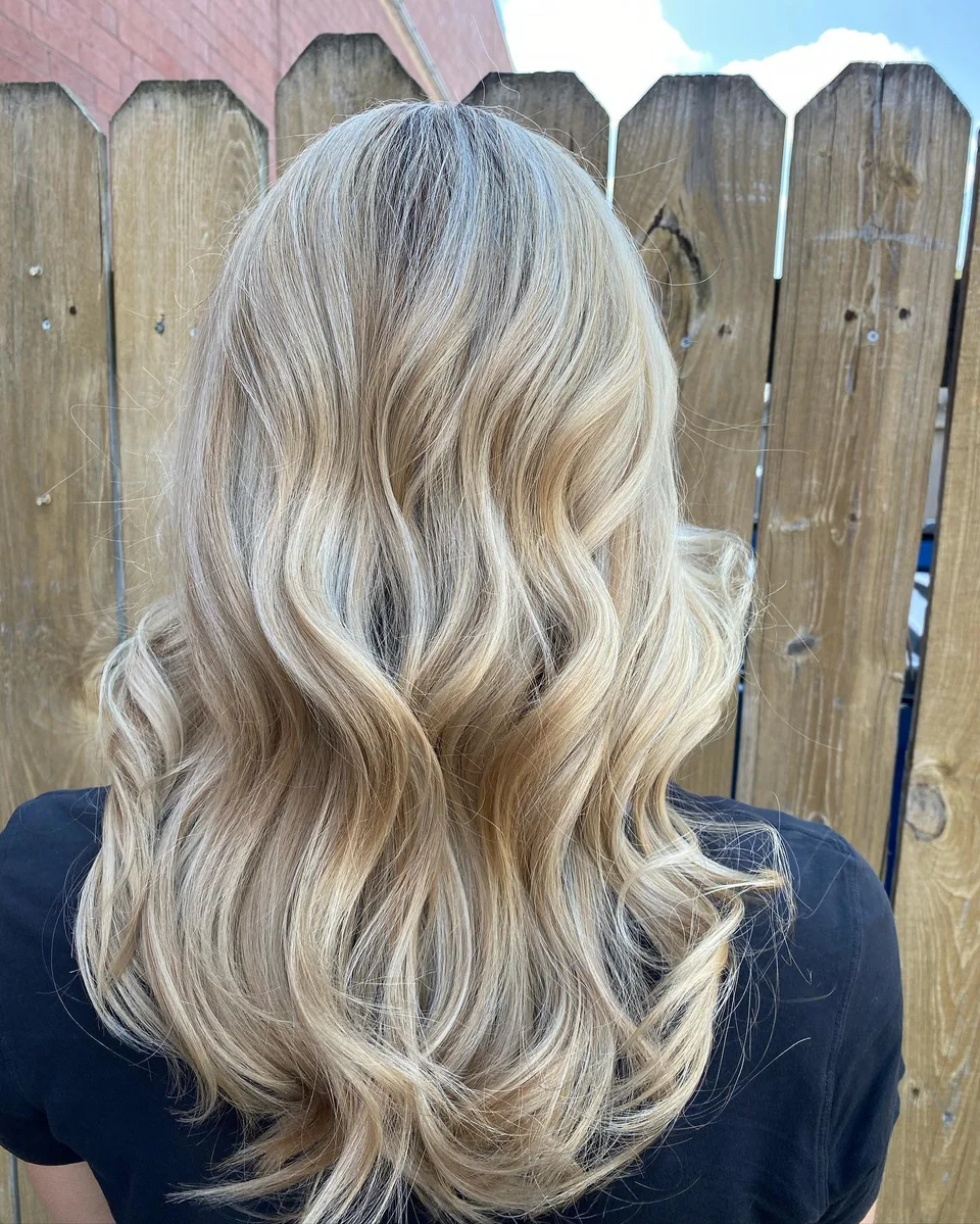 Cool blonde balayage styled in polished waves