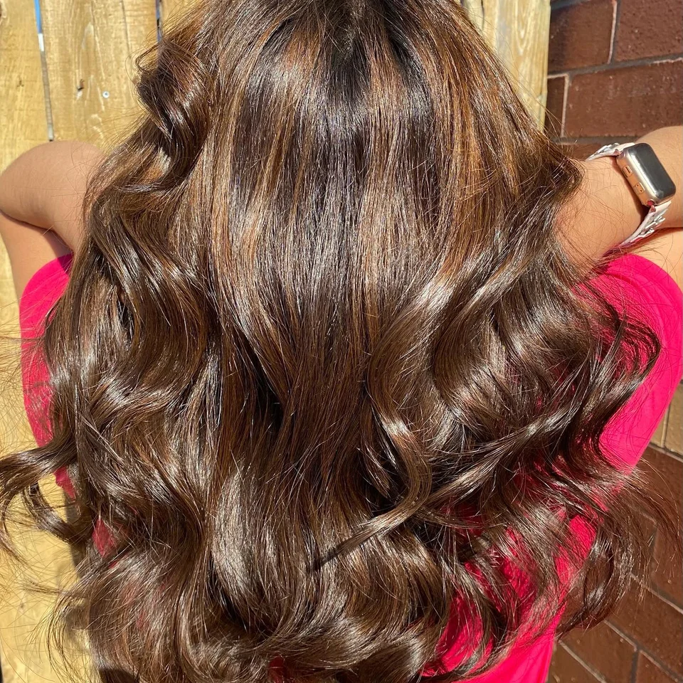 Rich chestnut brunette hair styled in glossy curls