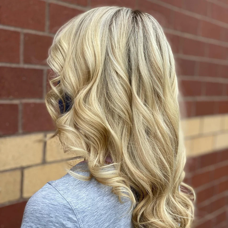 Golden blonde hair styled in side-swept curls