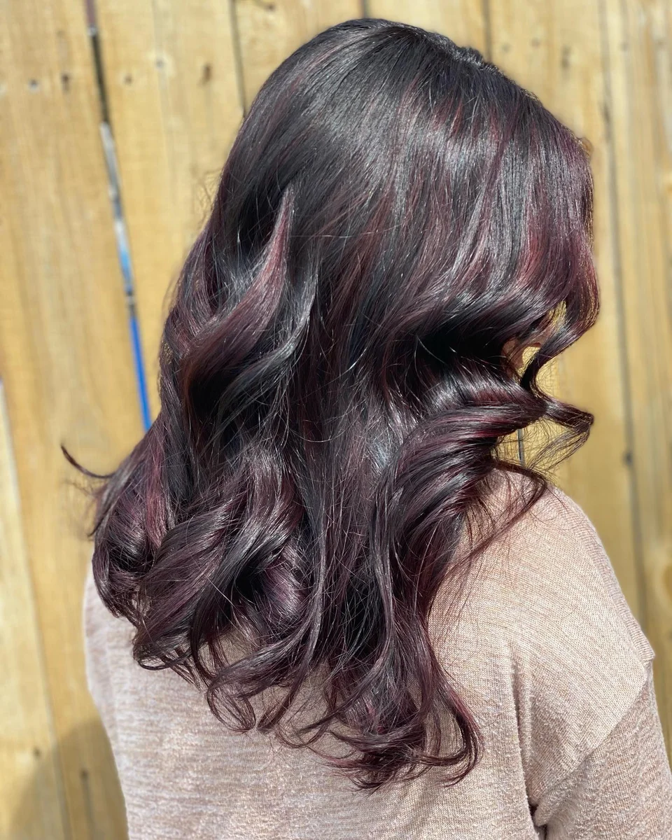 Deep burgundy hair styled in glossy curls