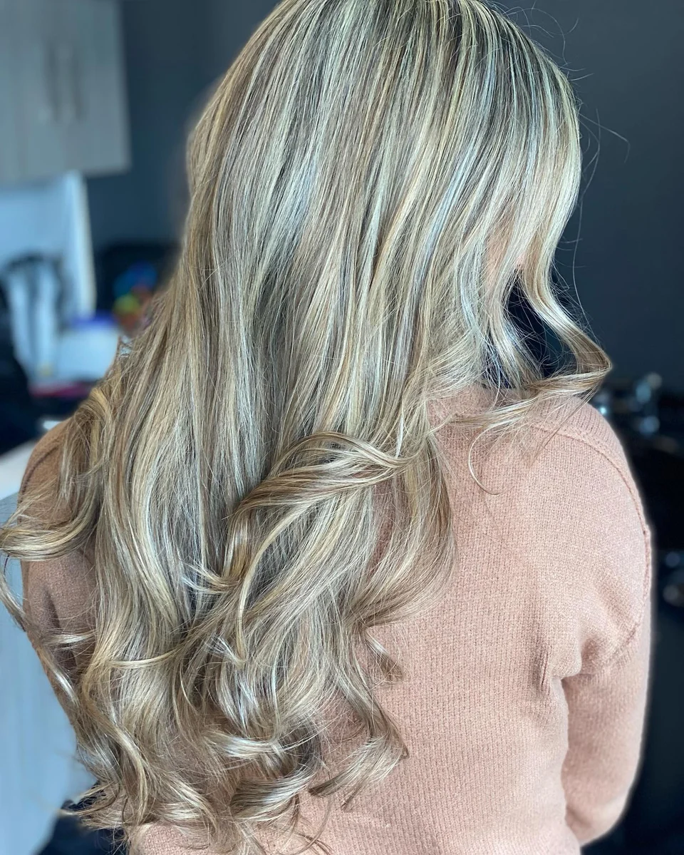 Long ash-blonde highlights styled in curls