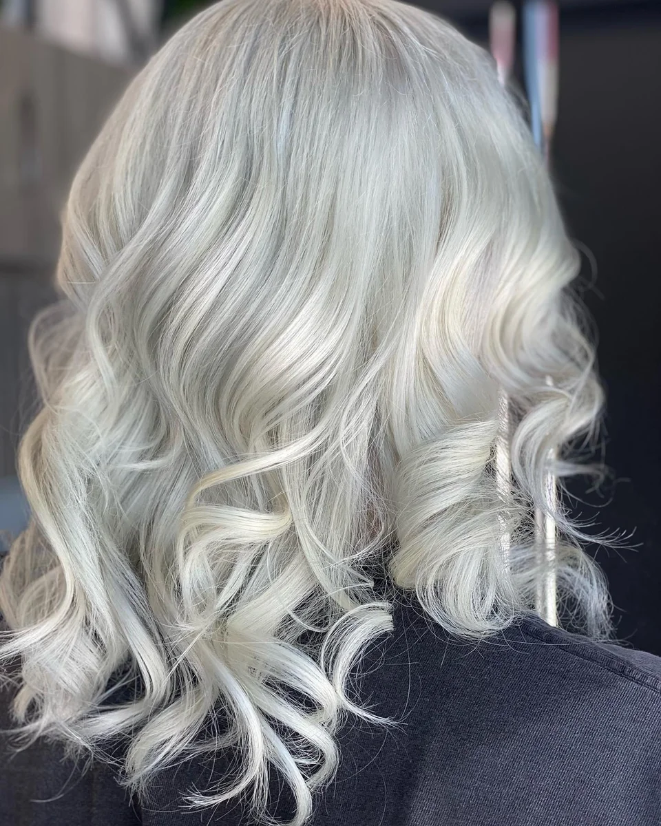 Icy platinum blonde hair styled in glossy curls