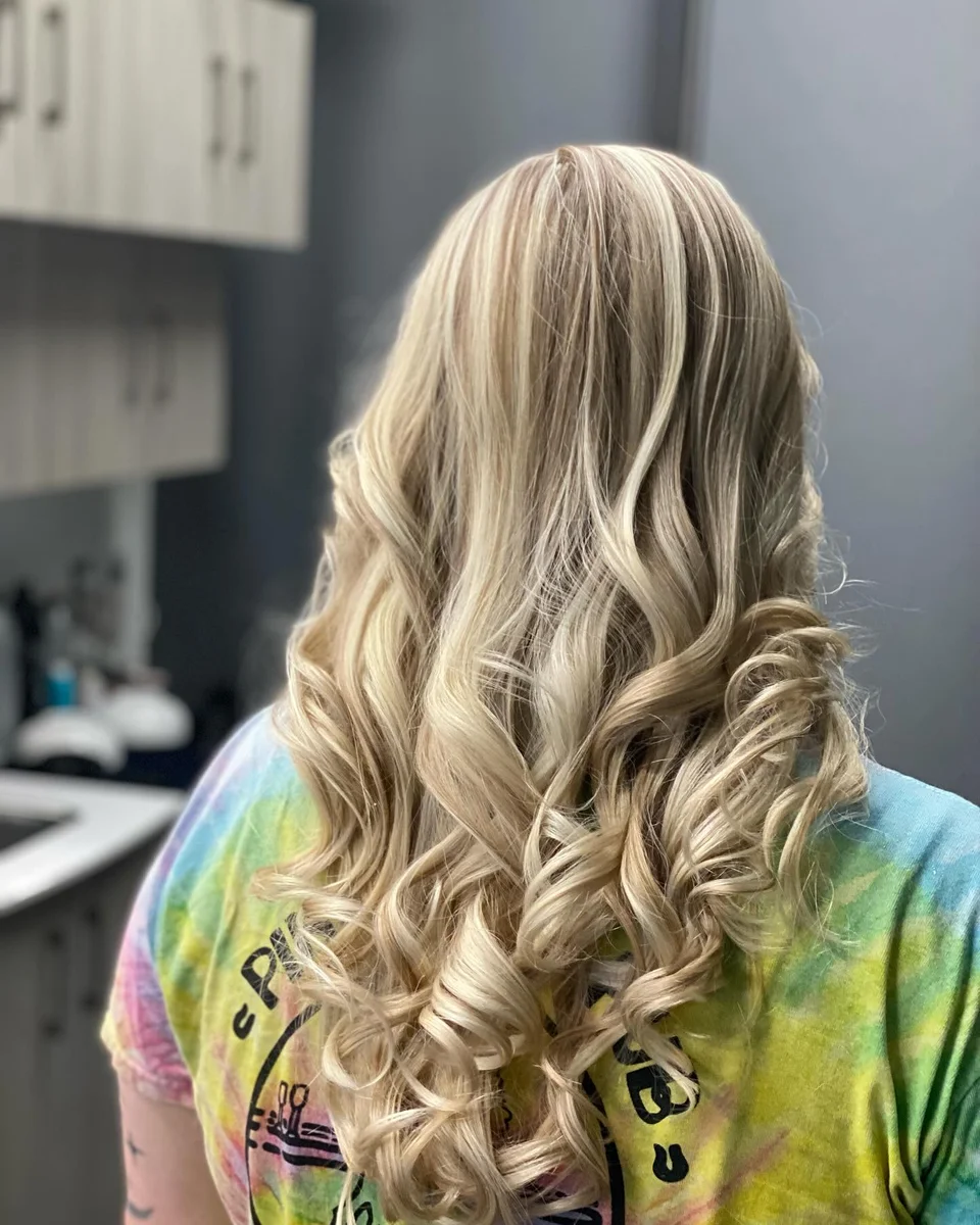 Long dimensional blonde hair styled in defined curls