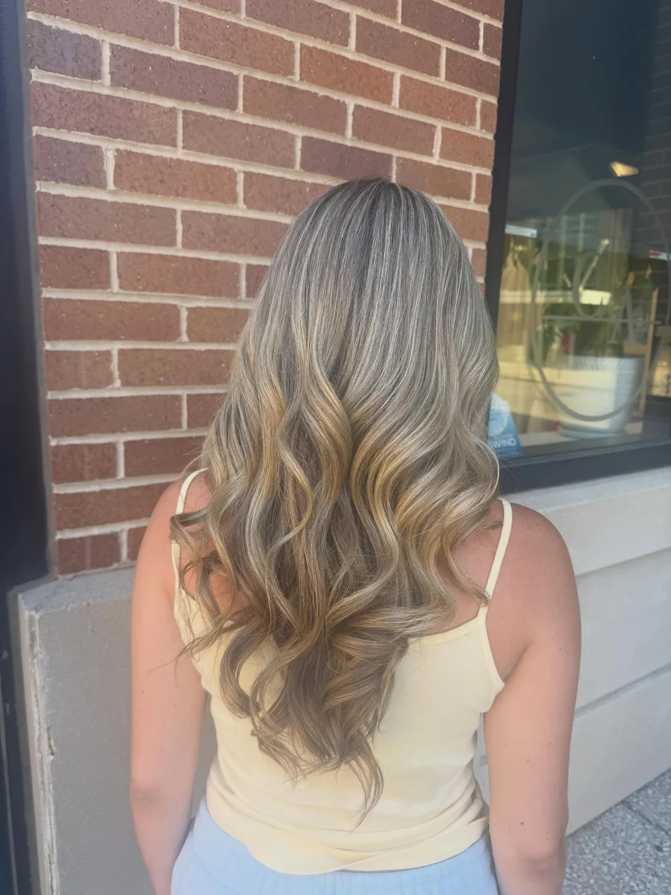 Long beige-blonde balayage styled in relaxed waves