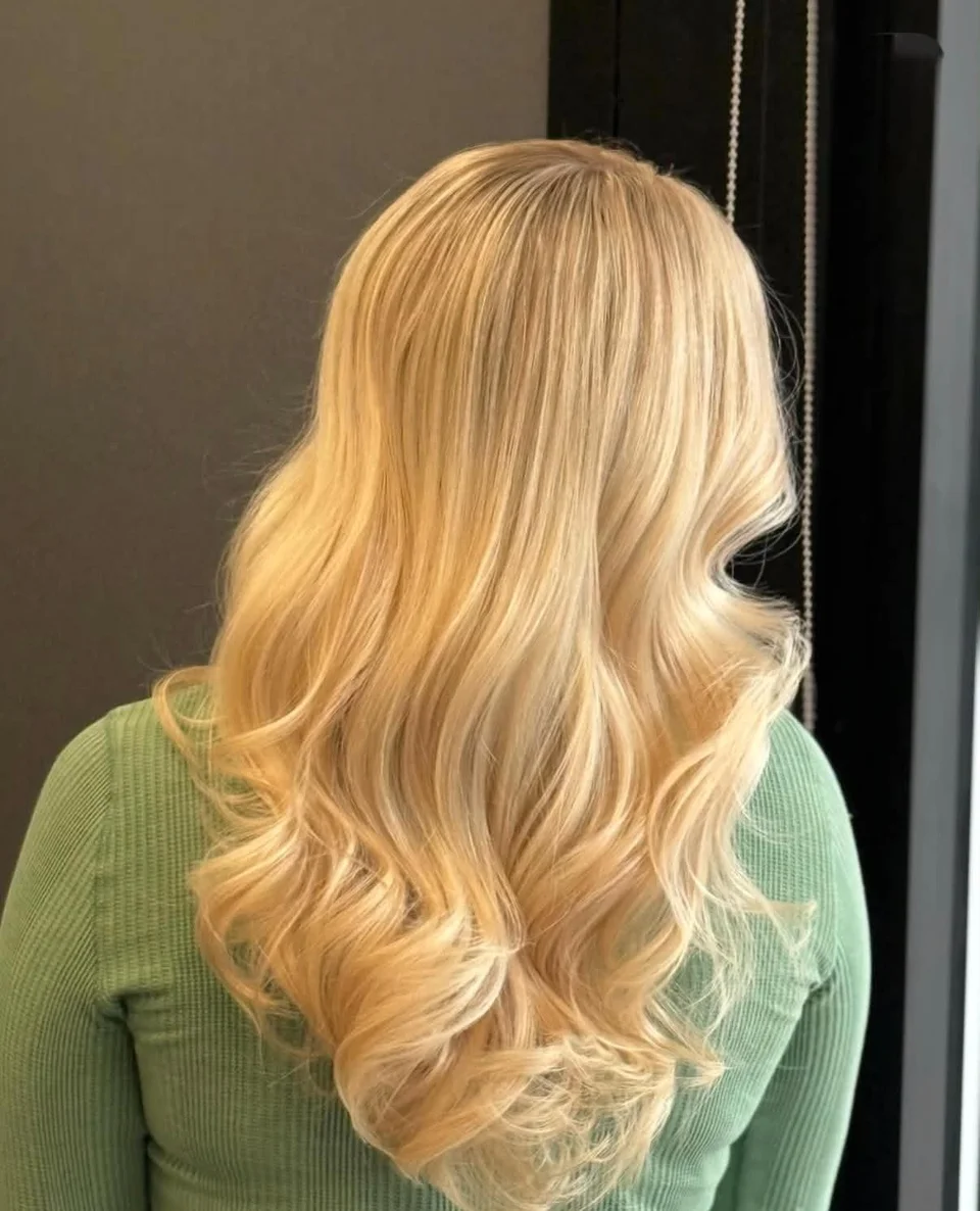 Long golden blonde hair styled in soft flowing waves