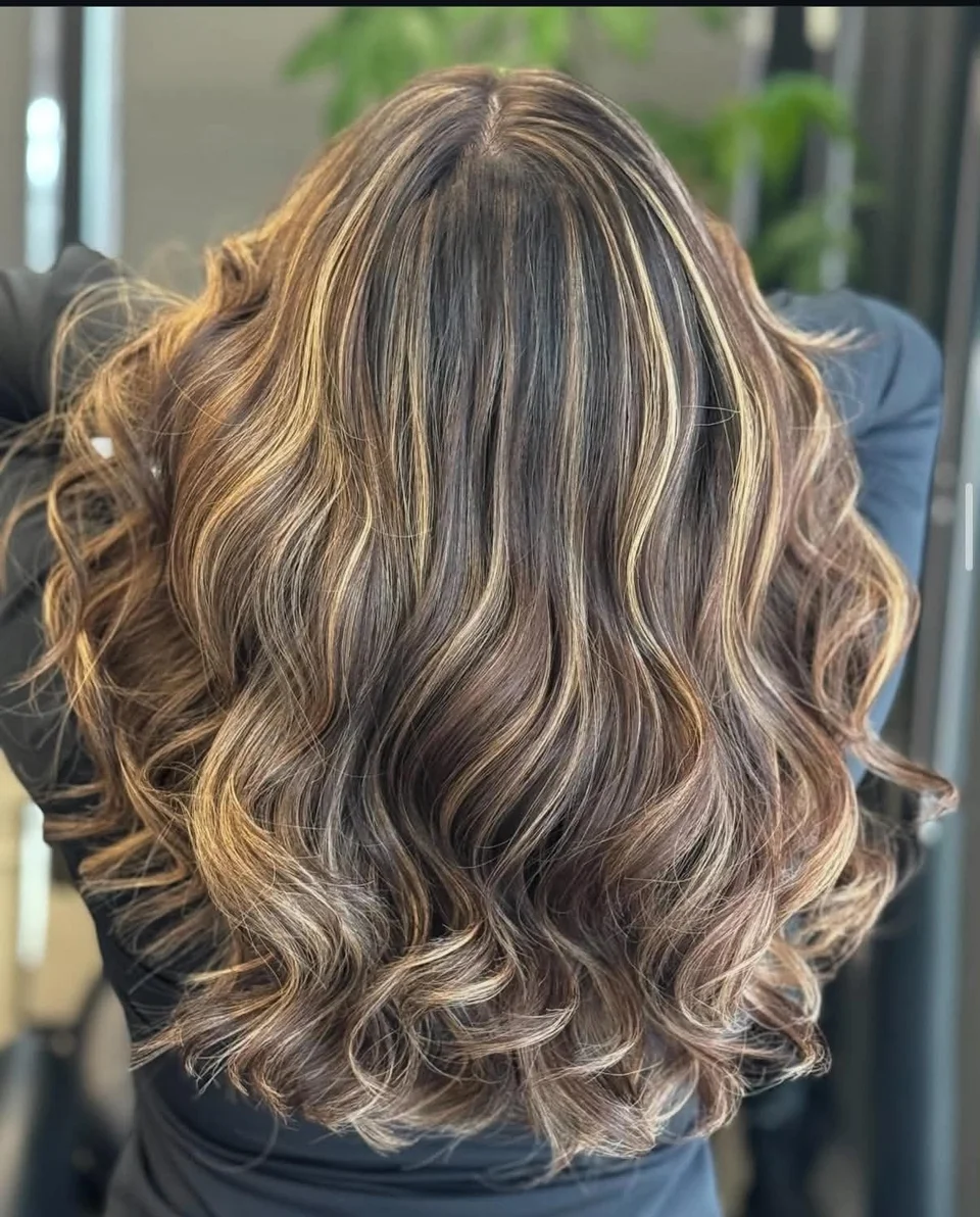 Long brunette curls with bright caramel ribbon highlights