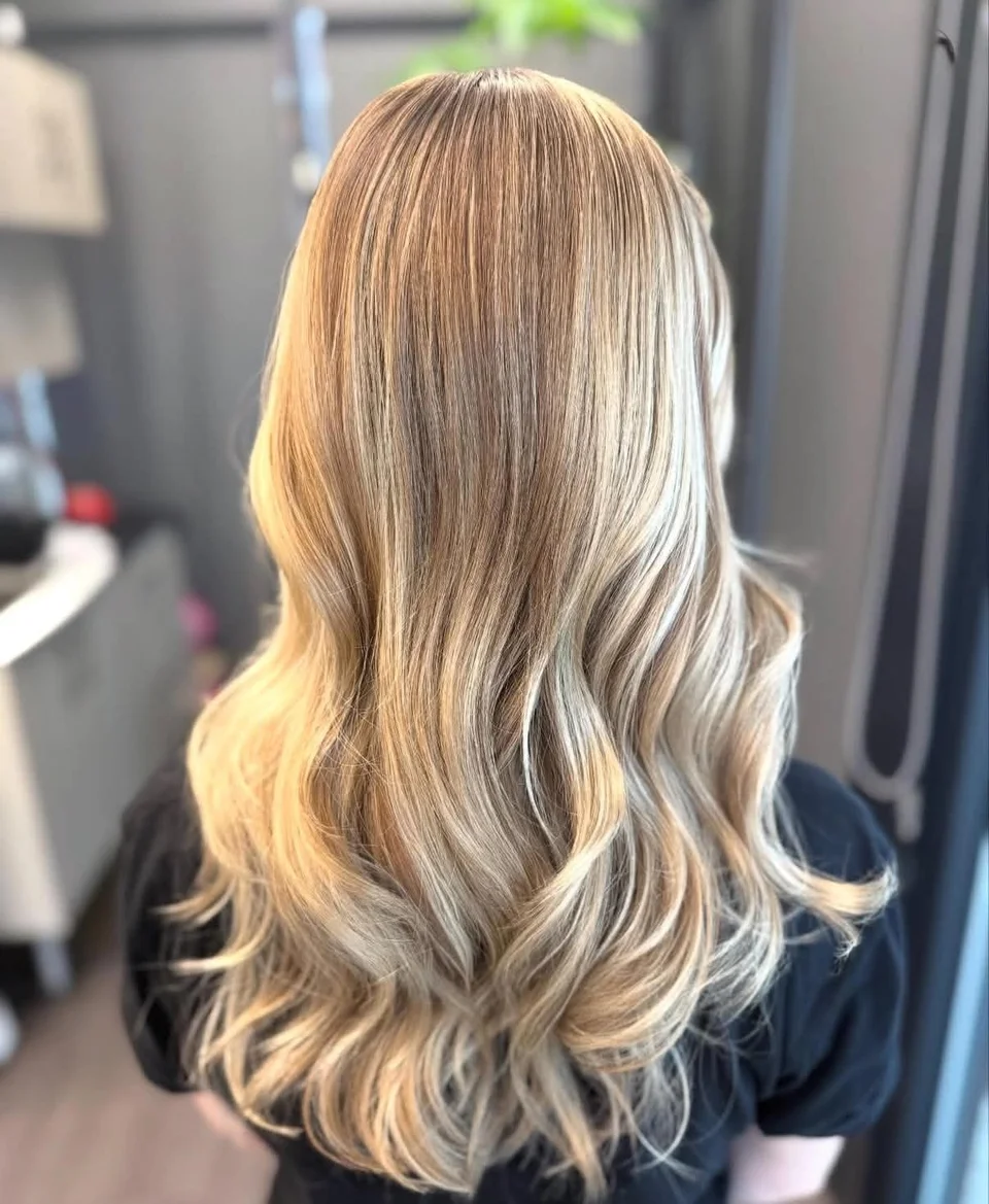 Long dimensional blonde hair styled in relaxed waves