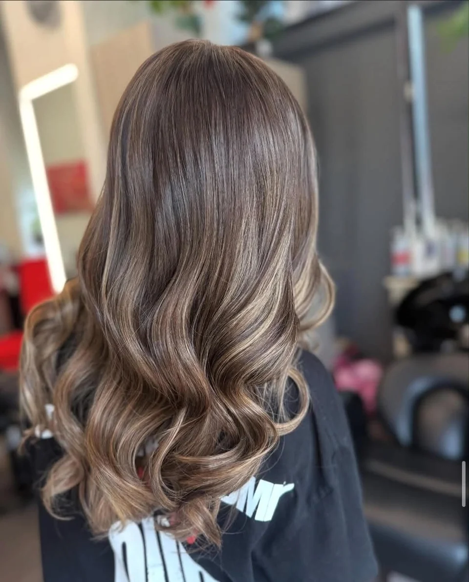 Glossy cool brunette hair styled in soft waves