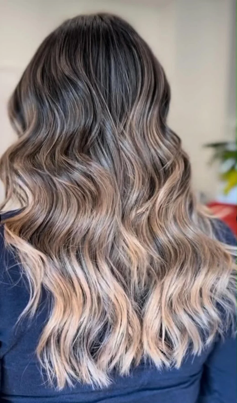Long smoky brunette balayage with pale blonde ends styled in flowing waves