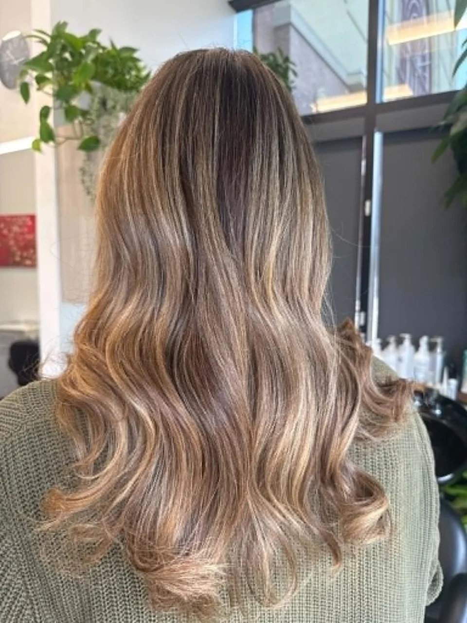 Long neutral blonde balayage styled in smooth waves