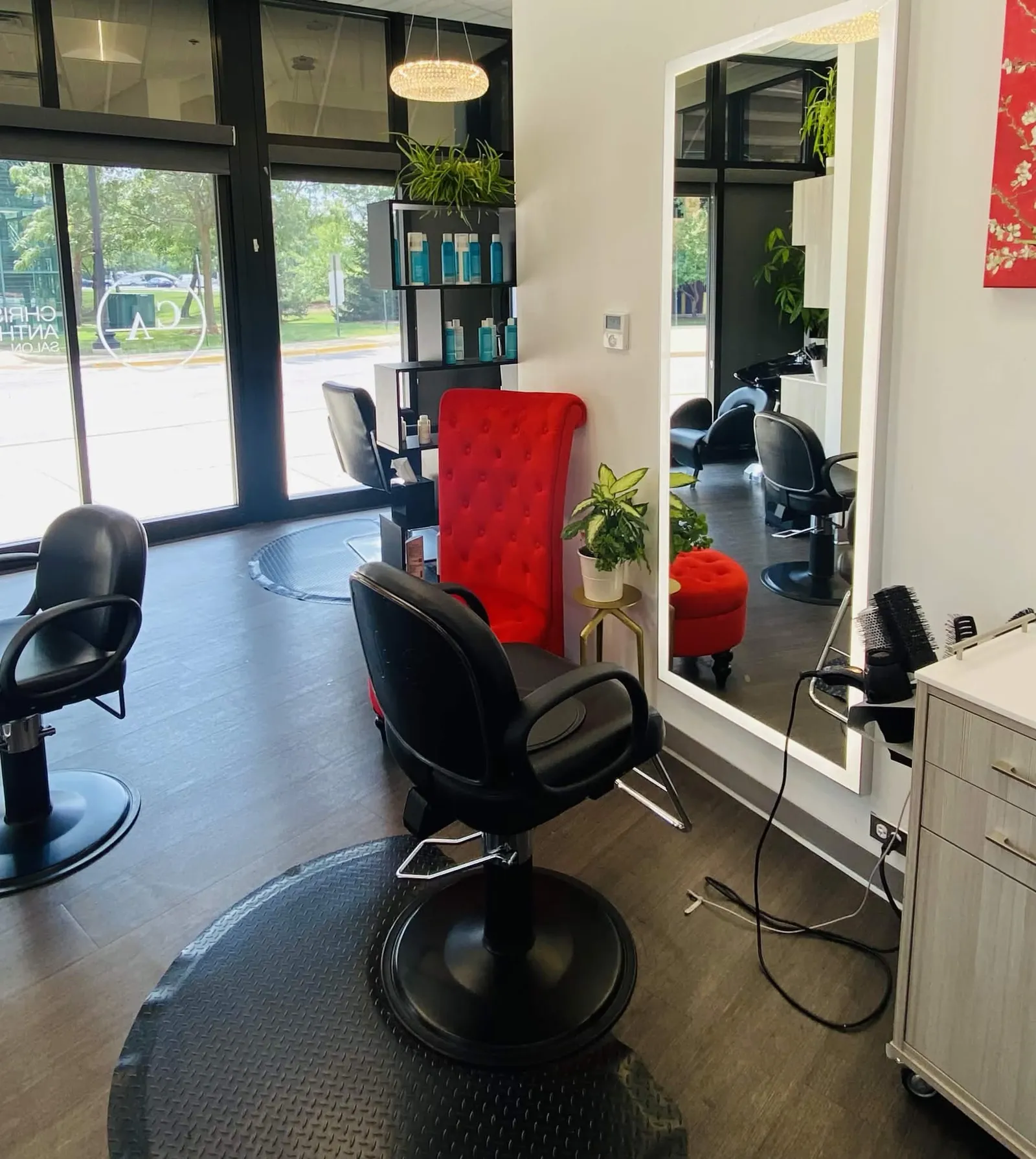 Christopher Anthony Salon styling stations with illuminated mirrors and the signature red guest chair