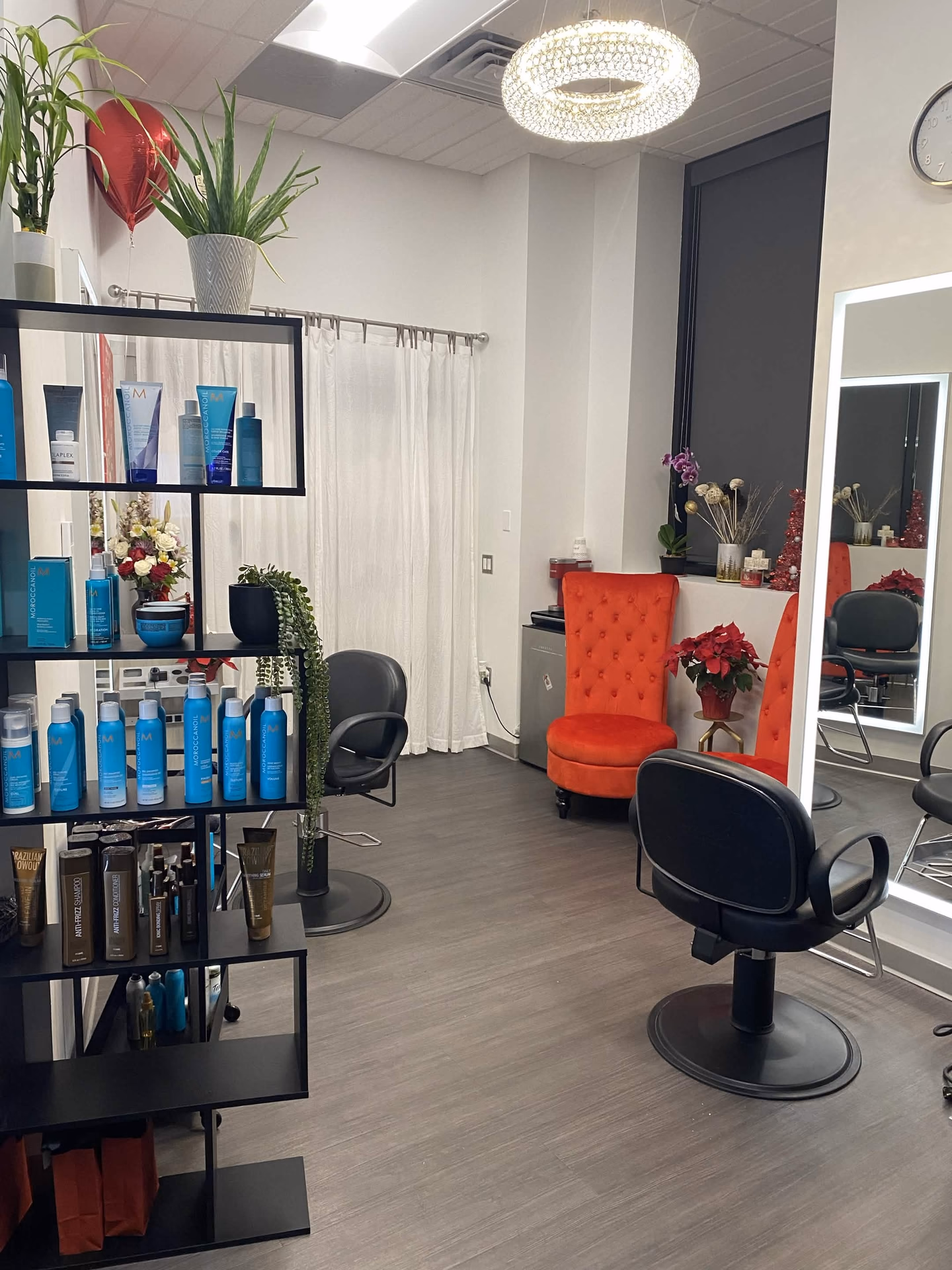 The salon floor with professional products, styling chairs, mirrors, and the red guest chair