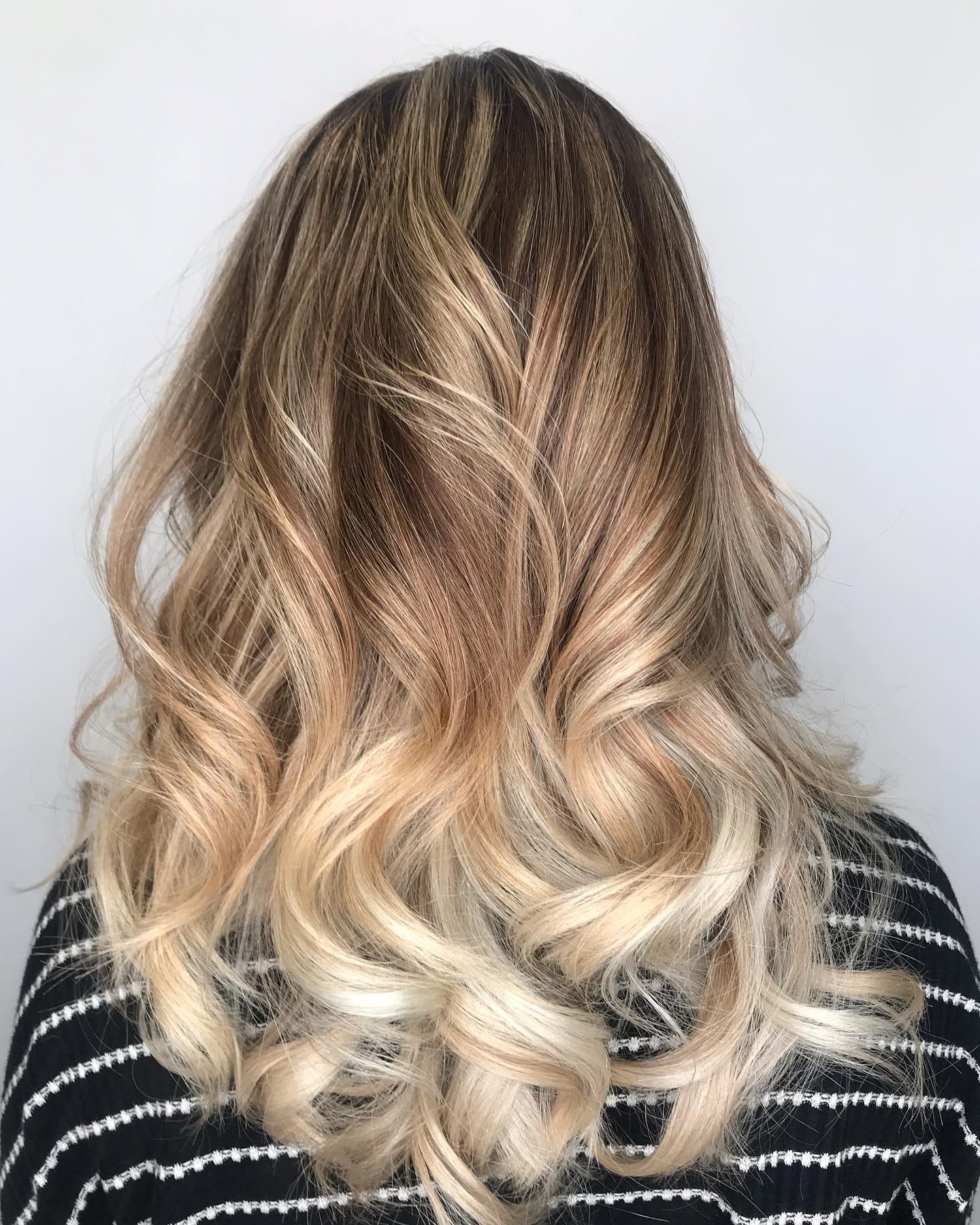 Long dimensional blonde balayage styled in curls