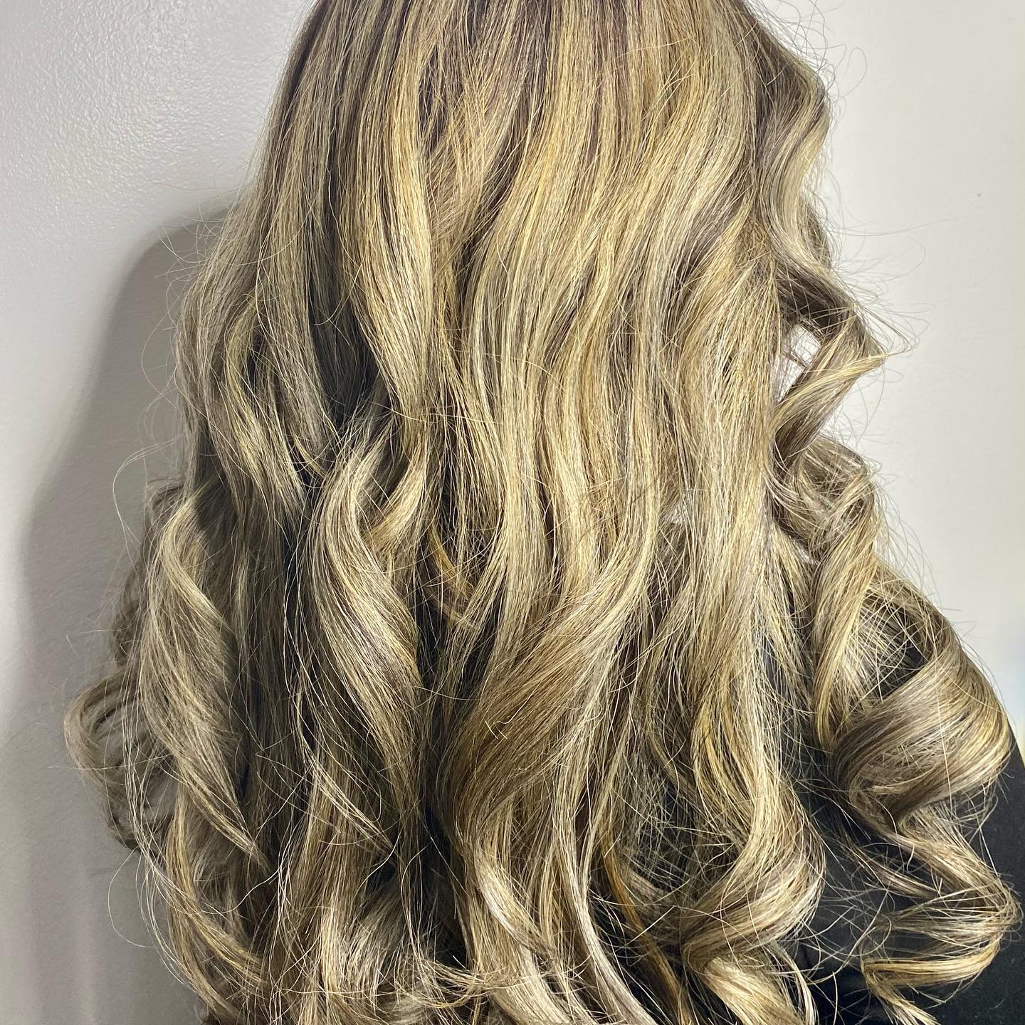 Long blonde highlights styled in soft curls