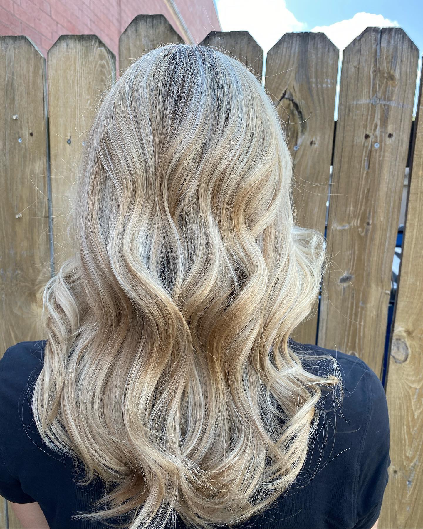 Cool blonde balayage styled in polished waves