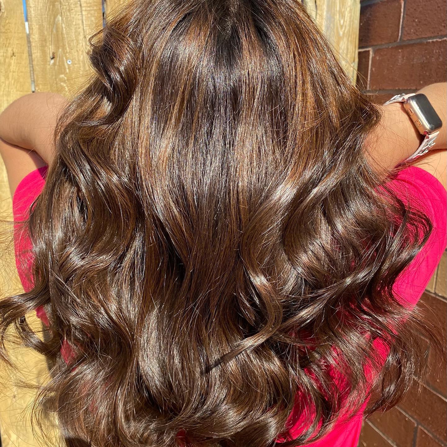 Rich chestnut brunette hair styled in glossy curls