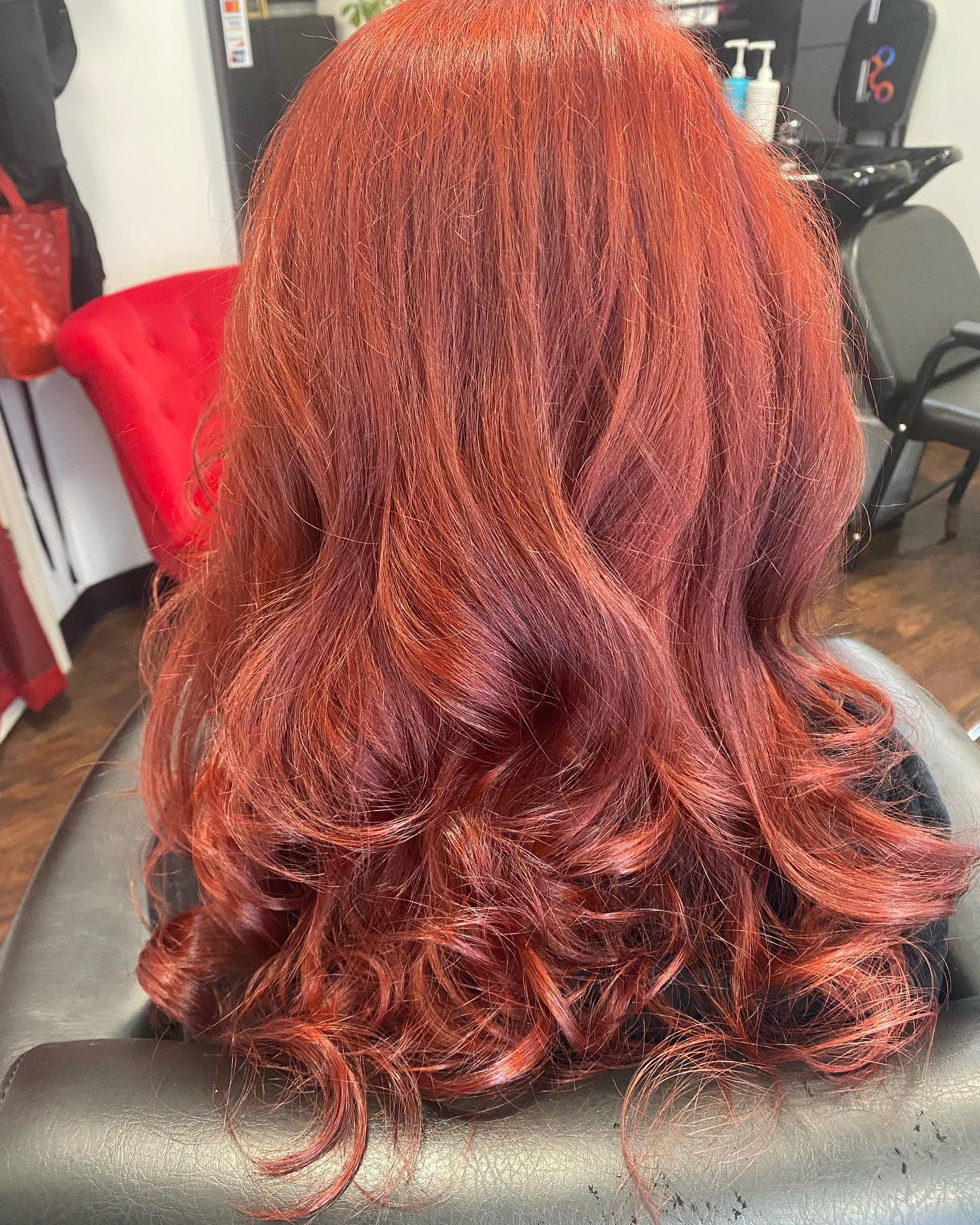 Vibrant copper-red hair styled in loose curls