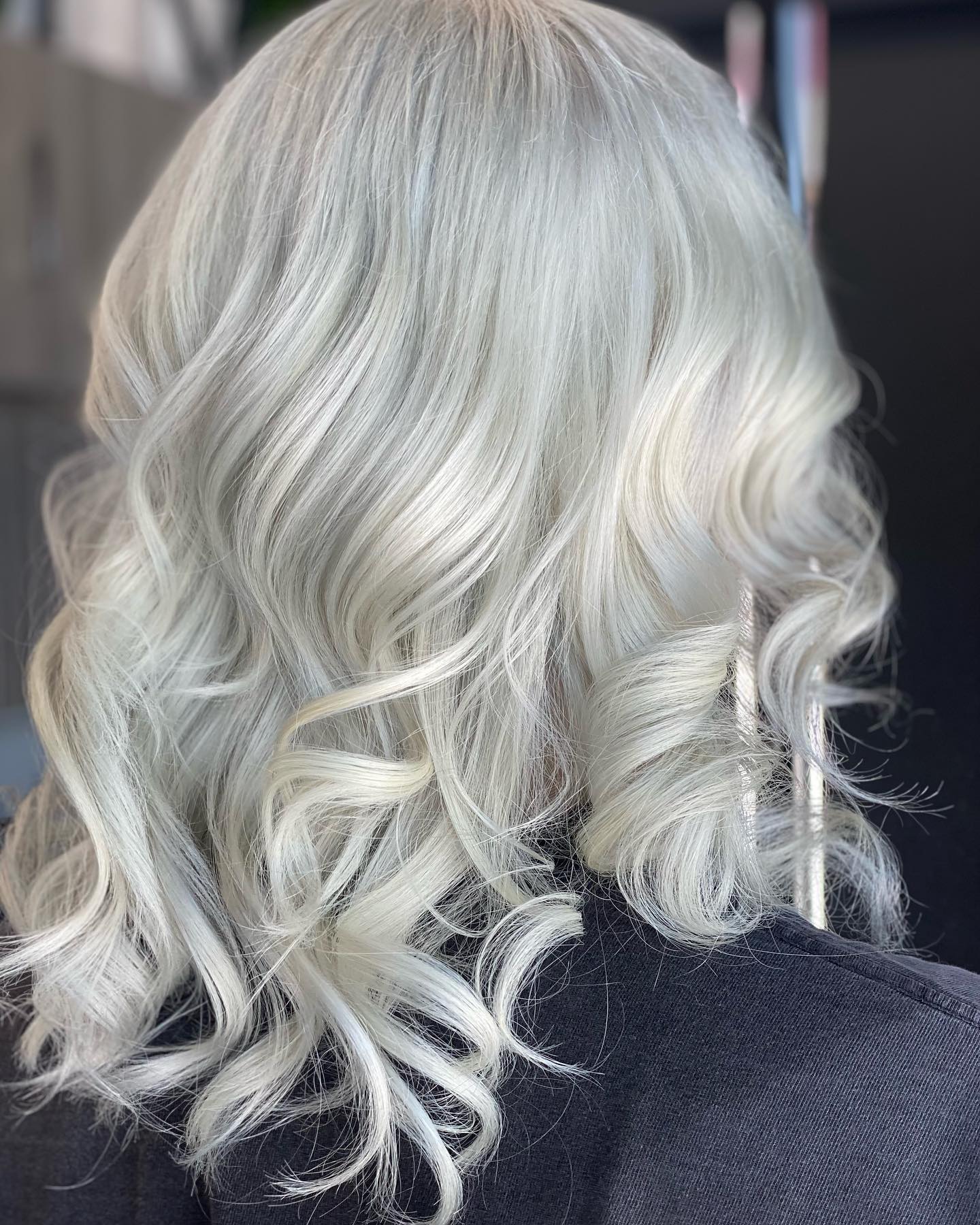 Icy platinum blonde hair styled in glossy curls