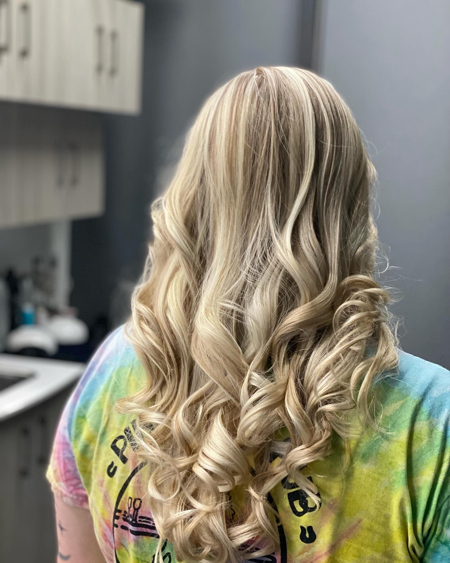 Long dimensional blonde hair styled in defined curls